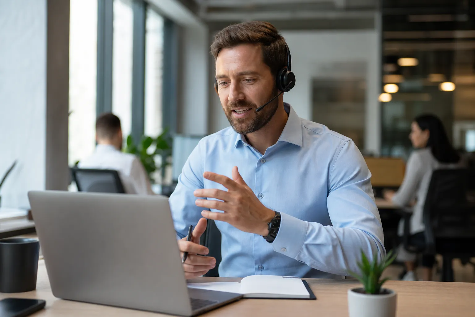 Vertriebsmitarbeiter führt Kaltakquise-Gespräch am Telefon mit Headset und CRM-System